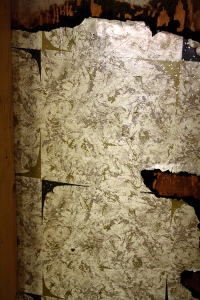 Vintage wall covering revealed by removal of paneling.
